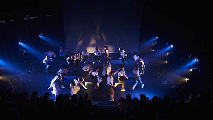 Students performing under a lightshow
